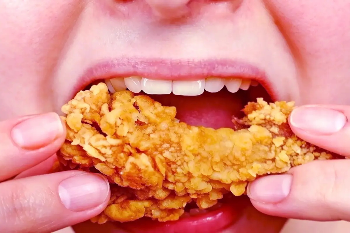 woman-eating-a-takeaway-fried-chicken-wing-from-fast-food-cafe-with-a-mouth-and-teeth-close-up